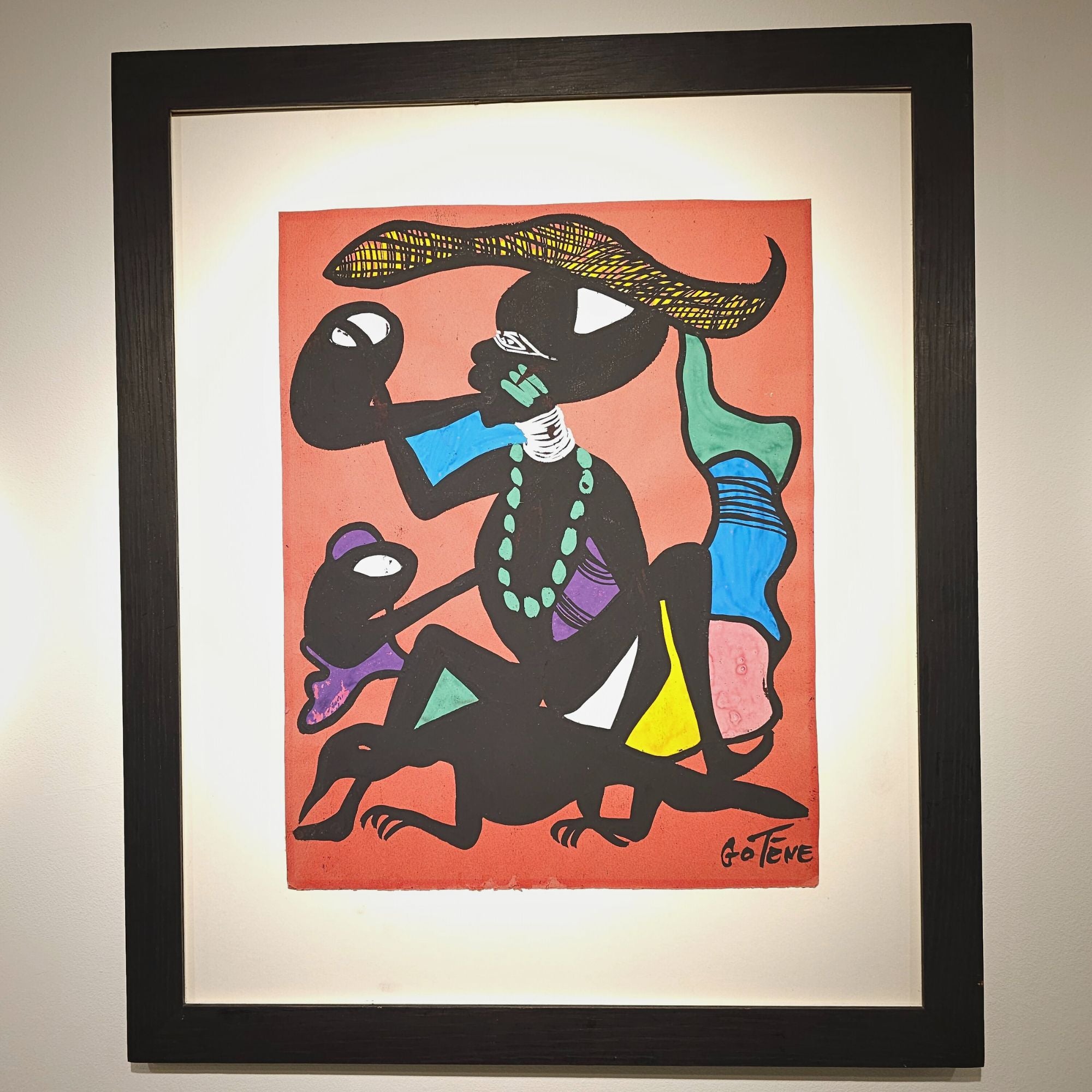 Framed artwork of a stylized figure with colorful clothing and accessories on a red background.