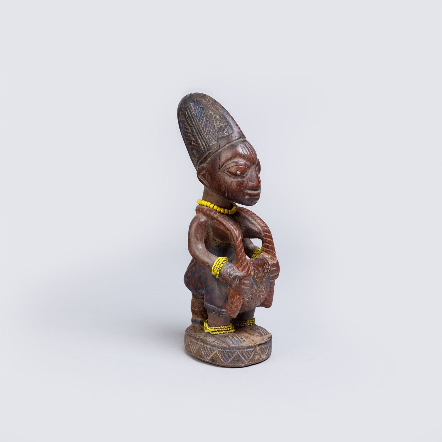 Wooden statue of a figure with intricate details on a white background