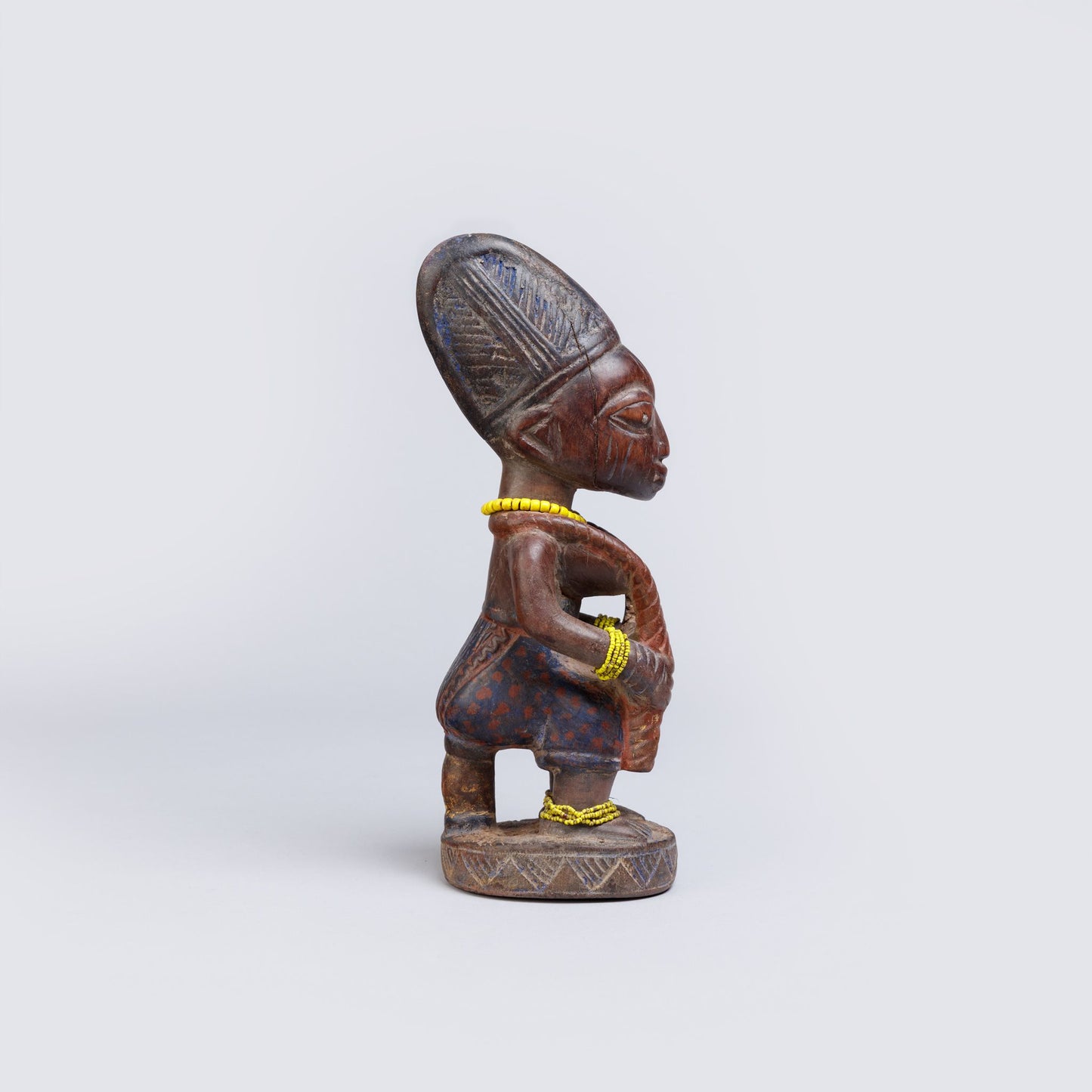 Wooden figurine with intricate carvings on a white background
