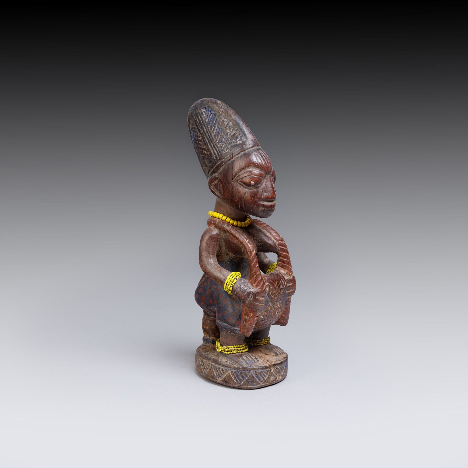 Wooden figurine with intricate carvings on a gray background