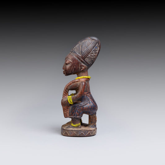 Wooden figurine with intricate carvings on a gray background