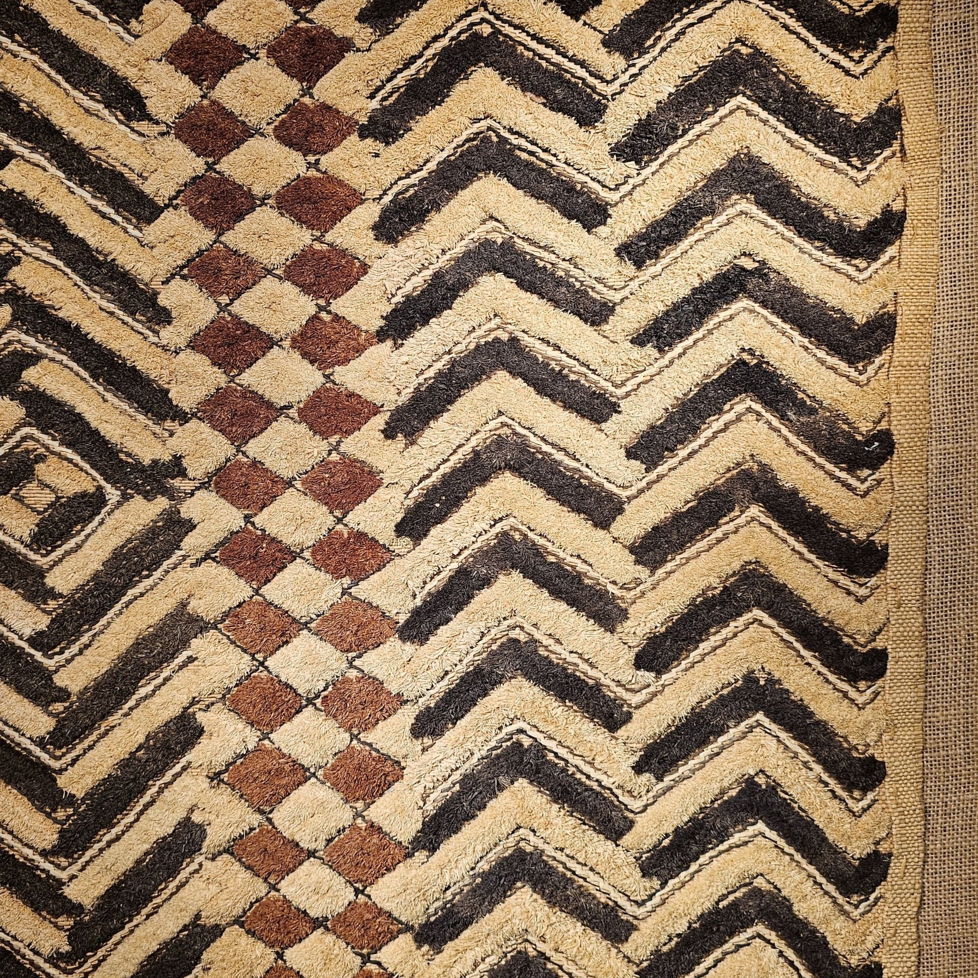 Close - up of a textured fabric with geometric patterns in black, brown, and beige. - AfrahouseAfrican Art